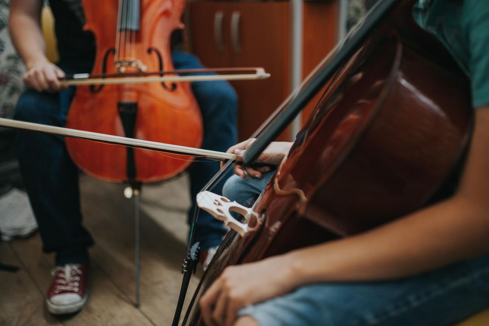 Students sitting in orchestra class with cello instruments