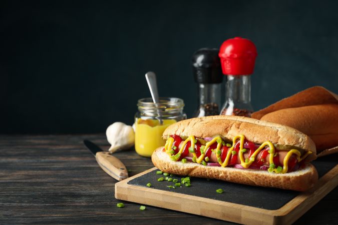 Tasty hot dog and ingredients on wooden background