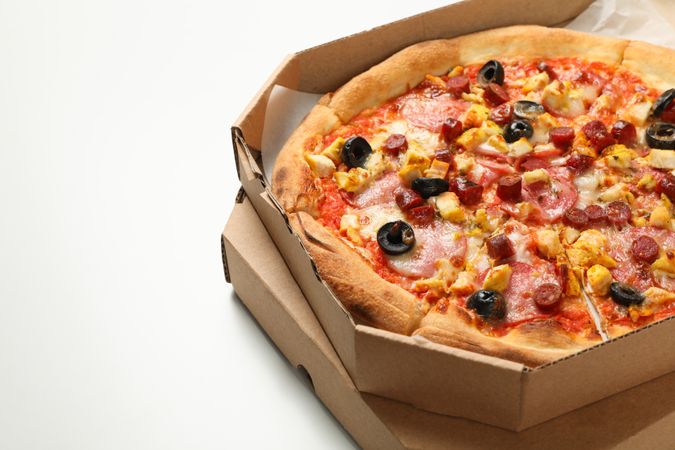 Tasty pizza in carton box on plain background