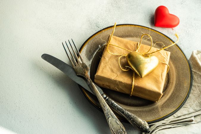 St Valentine day table setting with gift and gold heart, copy space