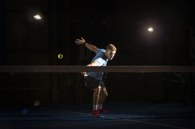 Man playing padel in darkness