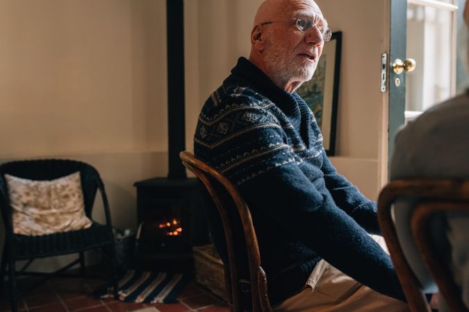 Man in sweater sitting at home talking to a person on a cold day