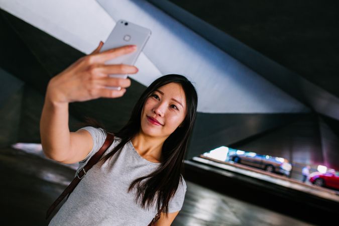 Asian female taking selfie in underground passage