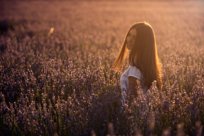 Female in blooming field during sunset