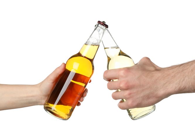 Hands hold bottles of cider, isolated on blank background. Cheers