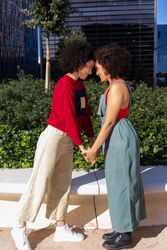 Side view of female couple holding hands and facing each other in park