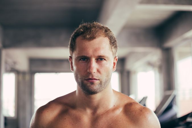 Portrait face of intense male looking at camera at the gym