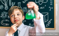 Thoughtful boy dressed as chemist with flask 5qkDlj