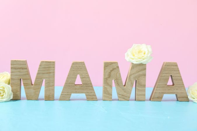 Inscription Mom with roses on blue table against color background, space for text