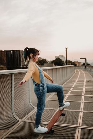 Girl with skateboard on walkway