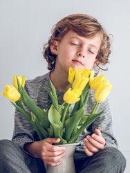 Cute boy with bouquet of tulips in vase