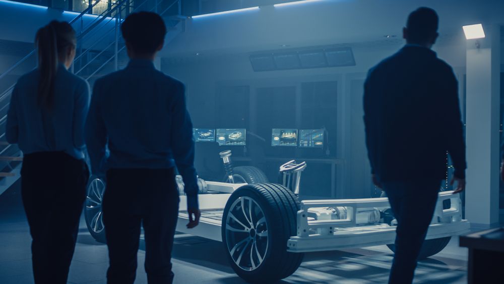 Team of Automobile Design Engineers Enter Automotive Innovation Facility Start Working on Electric Car Platform Chassis Prototype that Includes Wheels, Suspension, Hybrid Engine and Battery