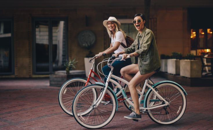 Female friends riding their bicycles on city street