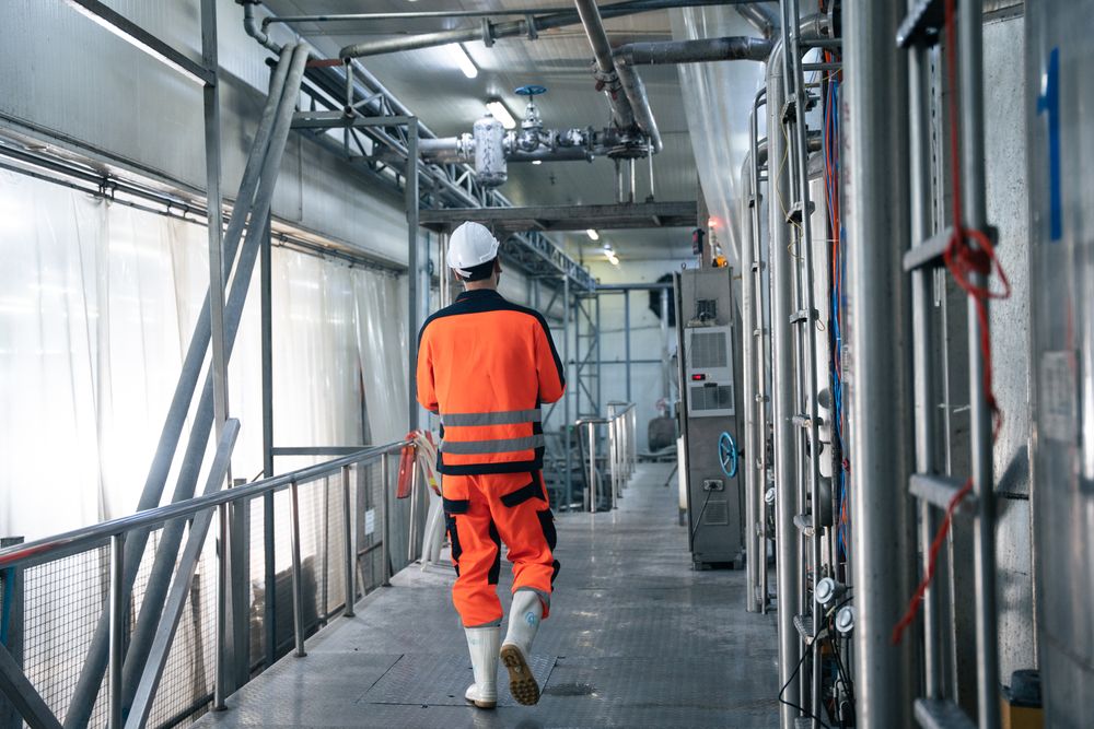 Engineer worker checking machine of conveyor belt system at the canned food factory.