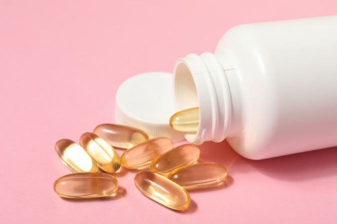 bottle with omega pills on a pink background