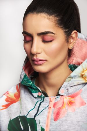 Beautiful woman pictured in colorful printed floral hoodie with her eyes closed