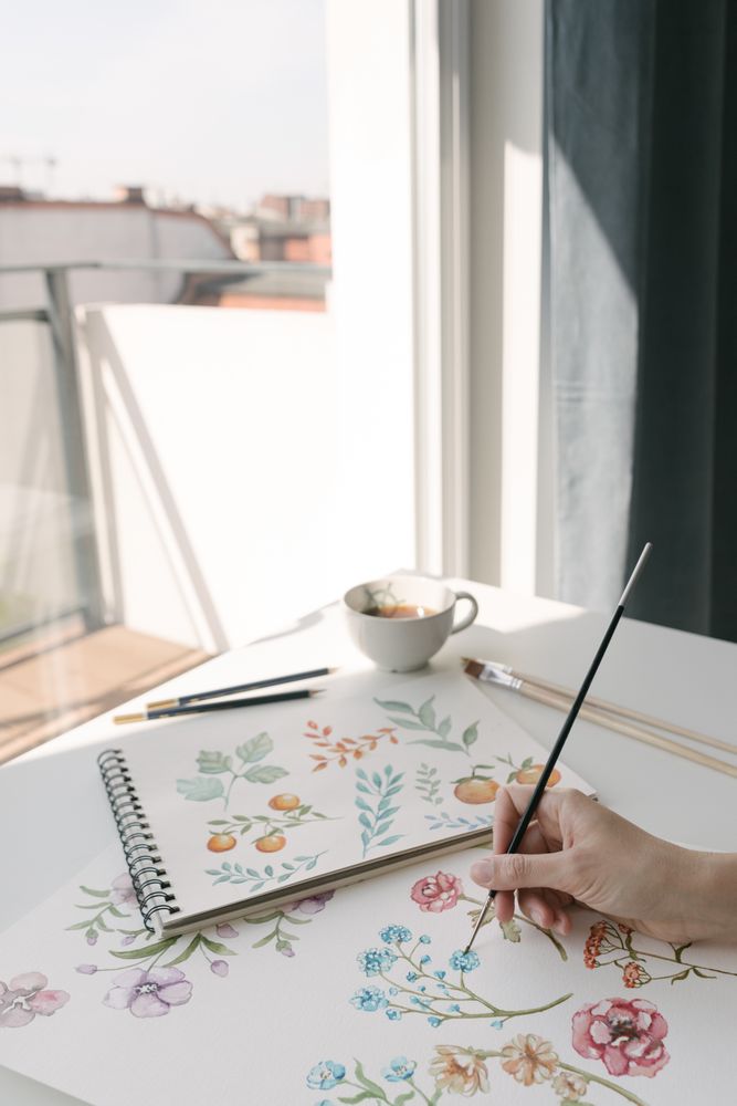 Person drawing flowers with watercolor