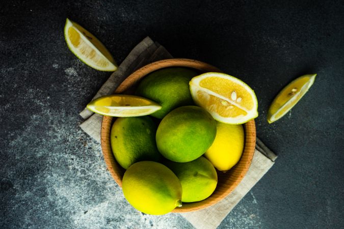 Bowl of lemons with a cut lemon on top