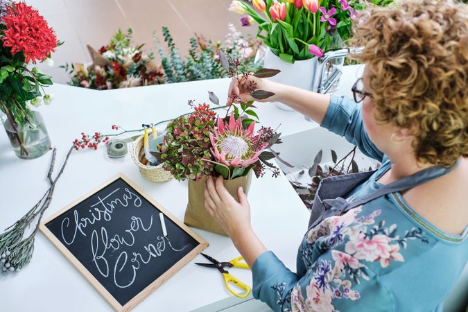 Crop woman arranging bouquet in flower shop