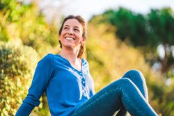 portrait of young woman sitting on grass in park