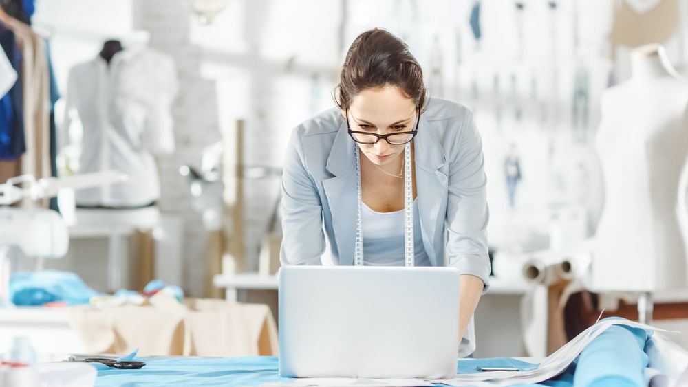 Portrait of a fashion, designer,  Working at Her Table on Laptop.