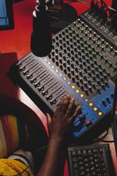 Crop Black person working with mixing console in studio