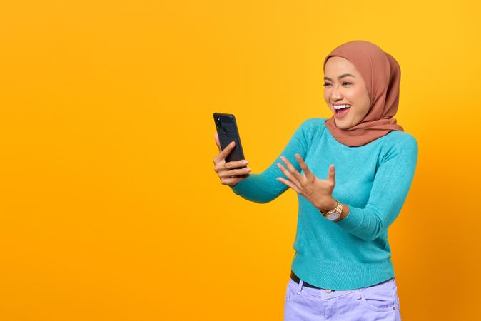 Excited Muslim woman pointing at copy space
