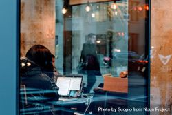 Woman using laptop in a coffee shop bYMMDb