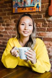 Woman in yellow sweater holding ceramic mug