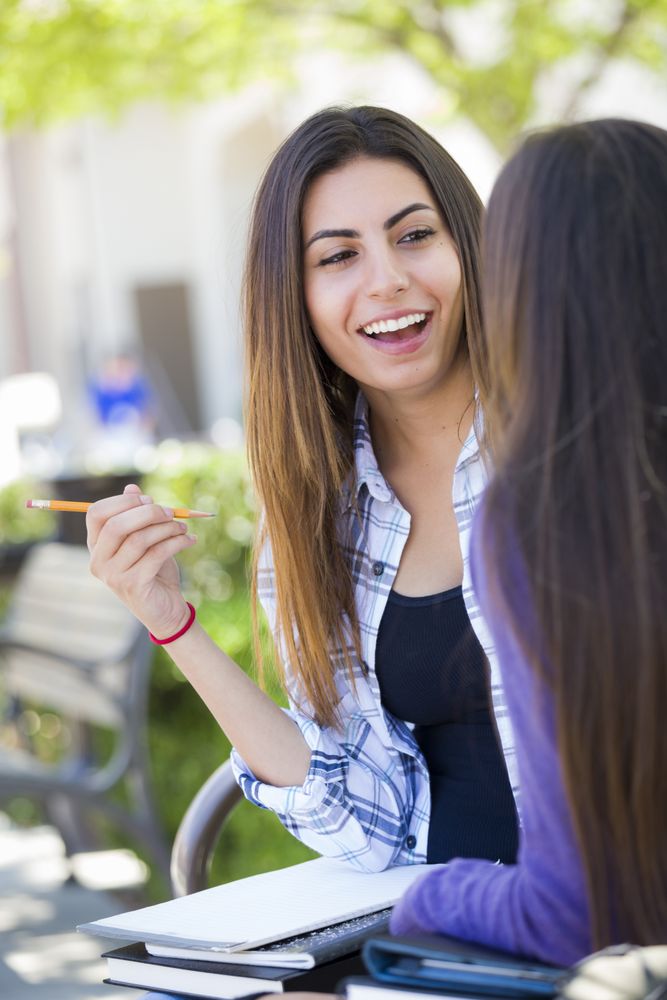 Expressive Woman Sitting and Talking with Girlfriend Outside