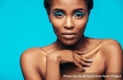 Close up of sensual woman wearing vivid makeup against blue background 0Pnve4