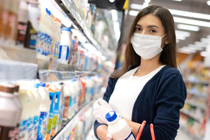 Woman grocery shopping in surgical mask