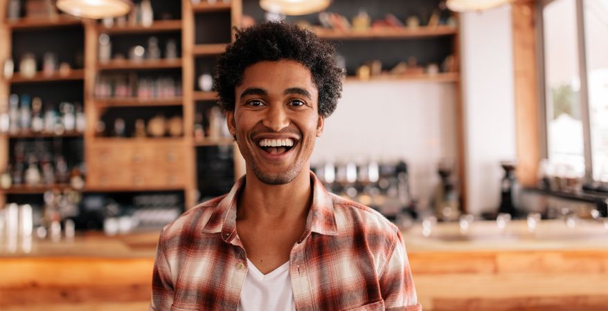 Portrait of happy young man laughing in a cafe