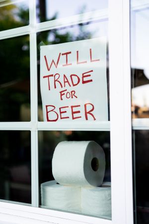 Sign from home asking to trade toilet paper for beer