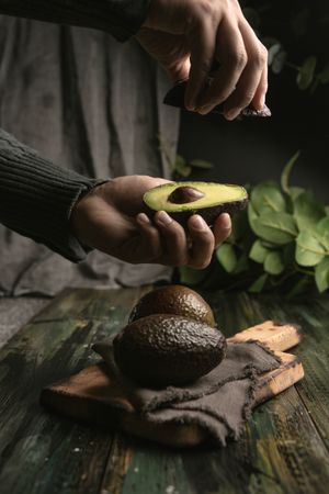 Person hands holding avocados