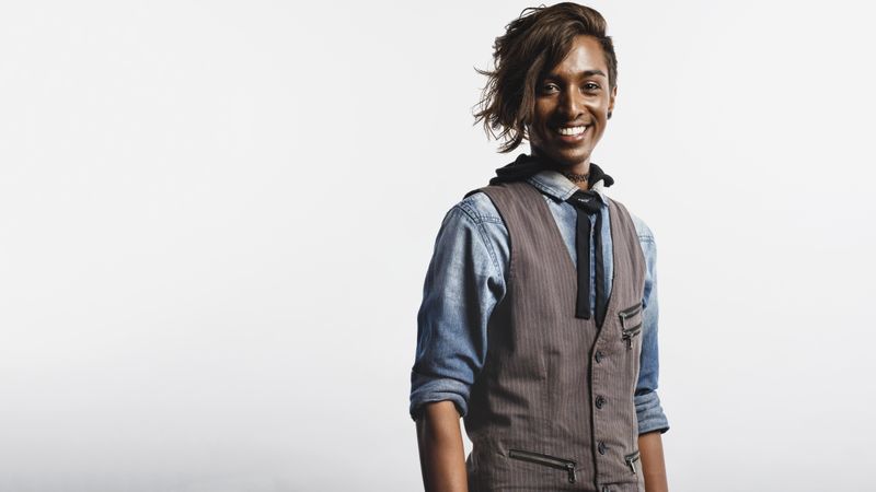 Happy young man in waist coat isolated on neutral background