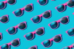Pattern of pink sunglasses on blue background