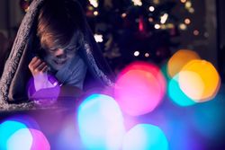 Positive boy reading book in dark room