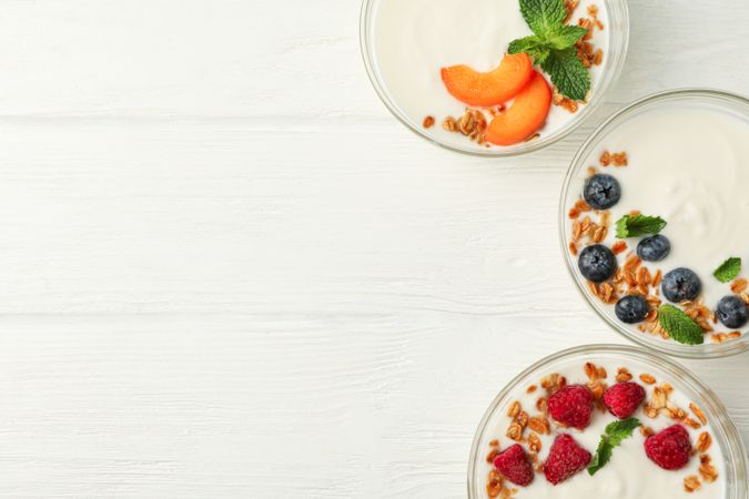 Flat lay composition with yogurt desserts and ingredients on wooden background