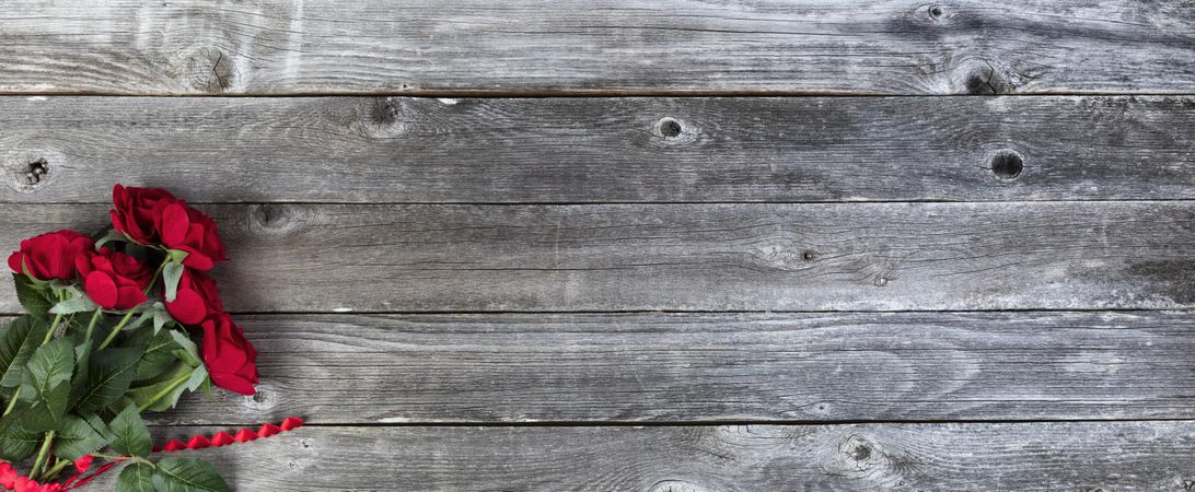 Happy Valentine’s day with roses and hearts on rustic wood