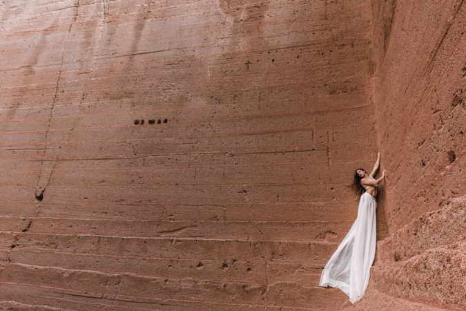 Elegant female posing on rocky cliff
