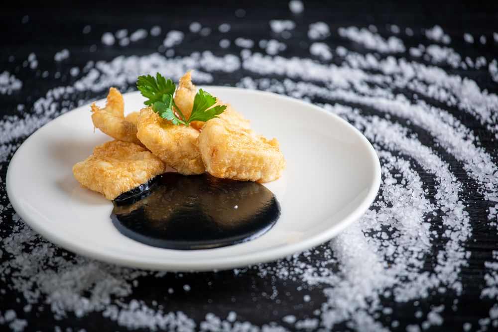 Hake breaded with squid cream in plate