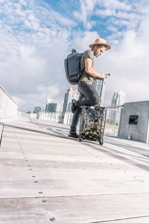 Full length portrait of hipster man with suitcase