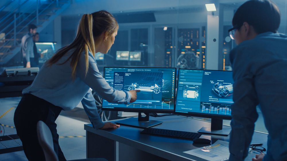 Female and Male Engineers are Discussing the 3D CAD Software Render of an Electric Car.