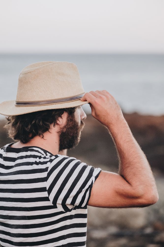 Bearded male in hat on deserted road
