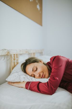 Woman sleeping and smiling in bed