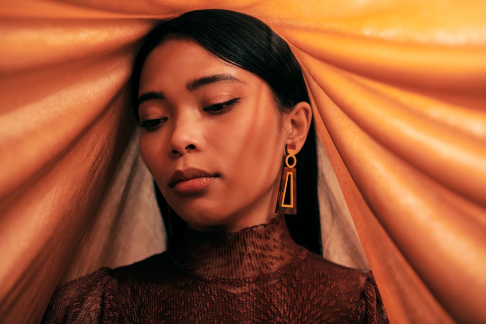 Young woman looking down with head draped in fabric