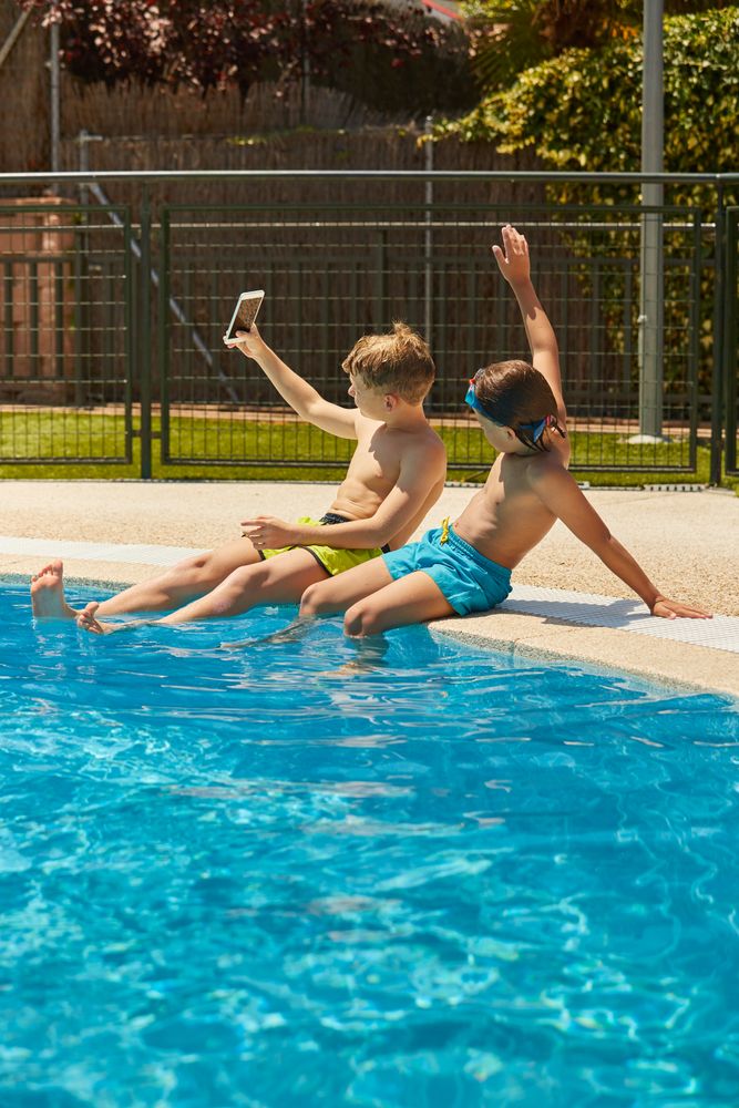 Boys on poolside taking selfie