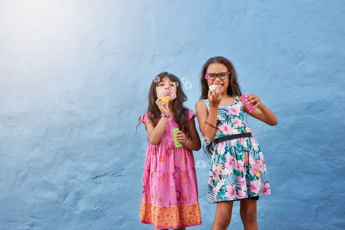 Portrait of cute little girls blowing bubbles