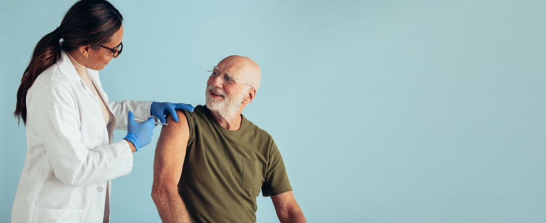 Mature man getting vaccine dose from a doctor